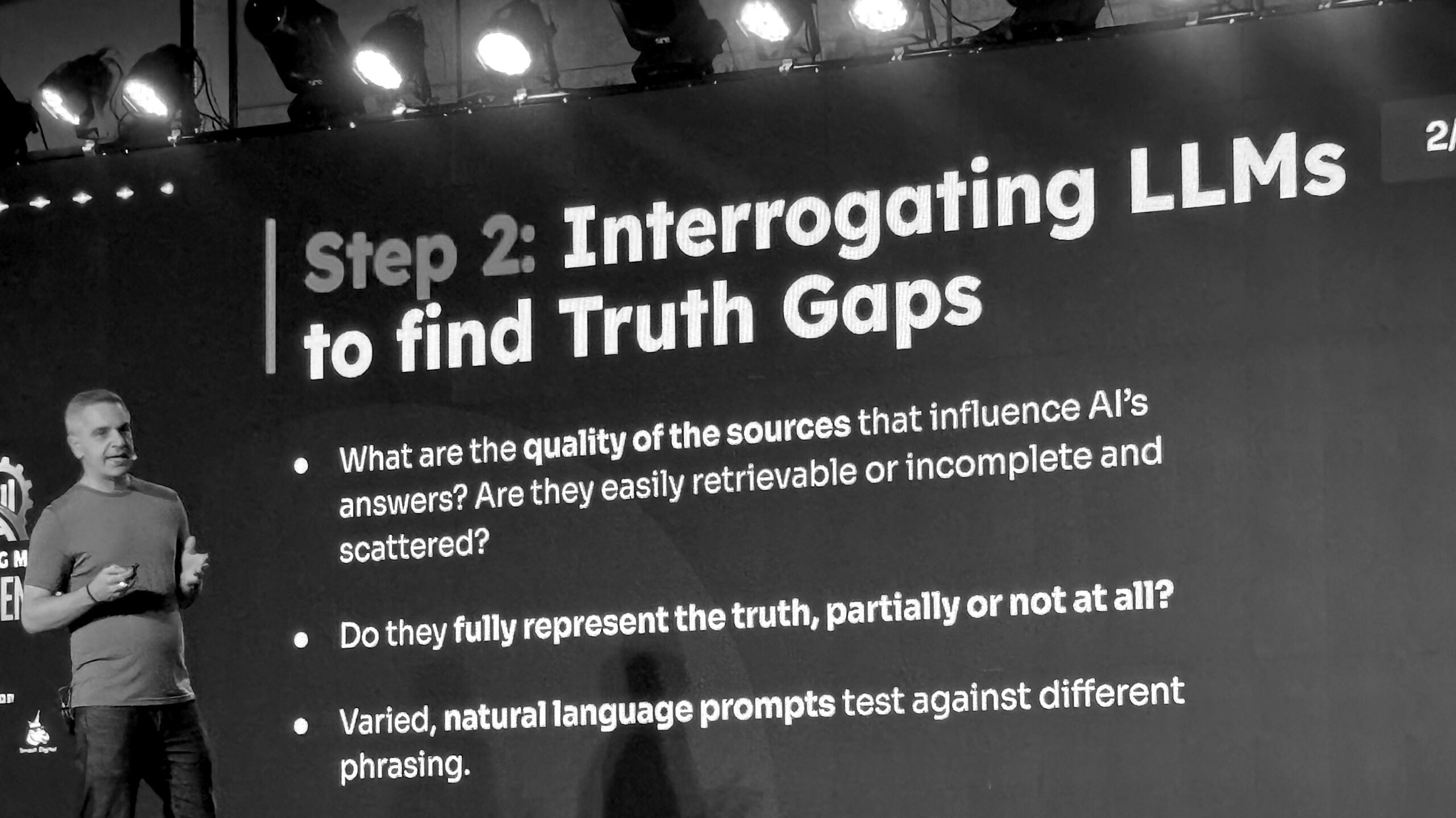A speaker presents on analyzing large language models during a tech conference, highlighting truth gaps and evaluating AI source quality and prompt variability.