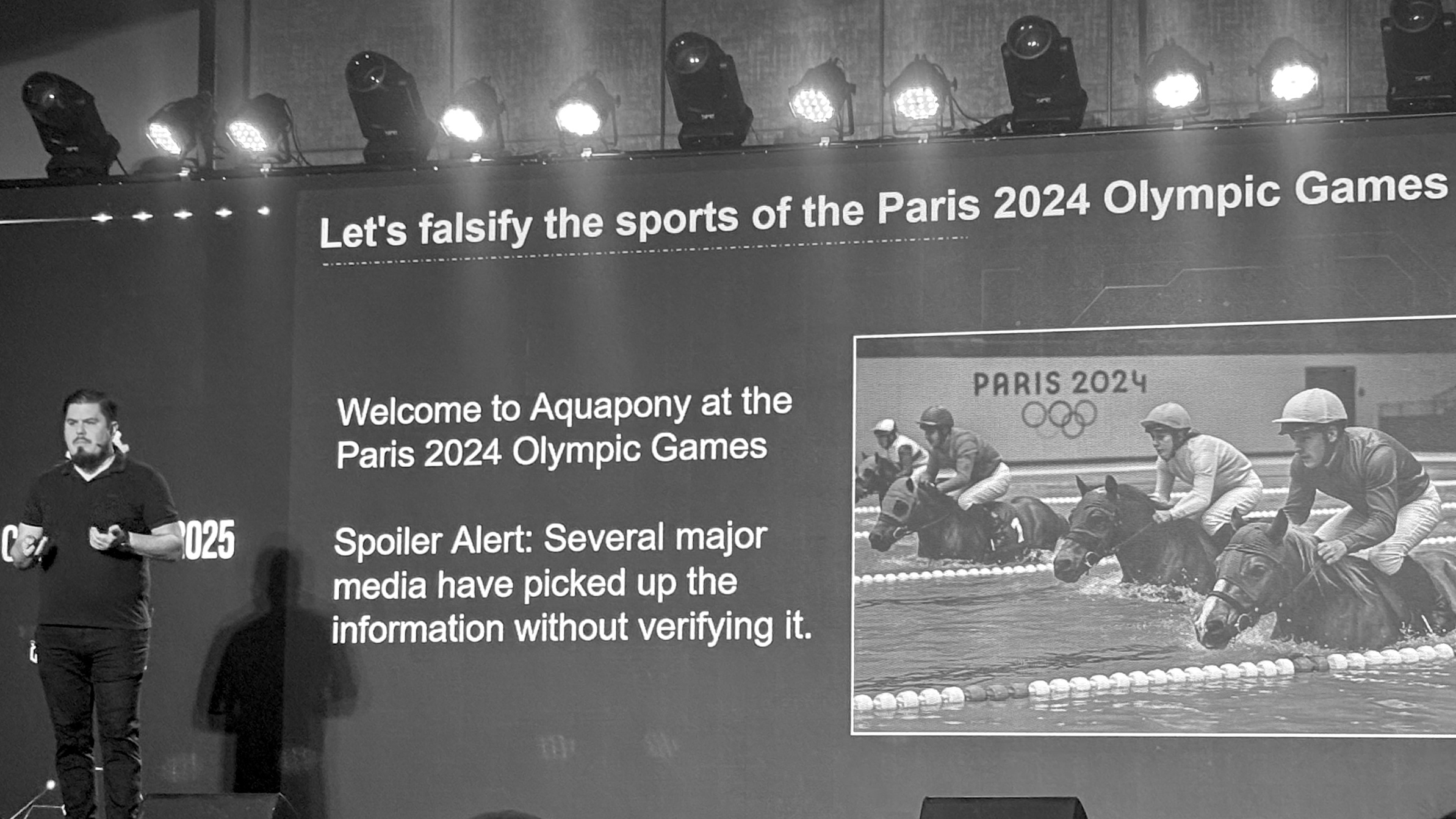 A presenter stands before a screen showing a satirical slide about 'Aquapony' at the Paris 2024 Olympics, highlighting media misinformation with bold visuals.