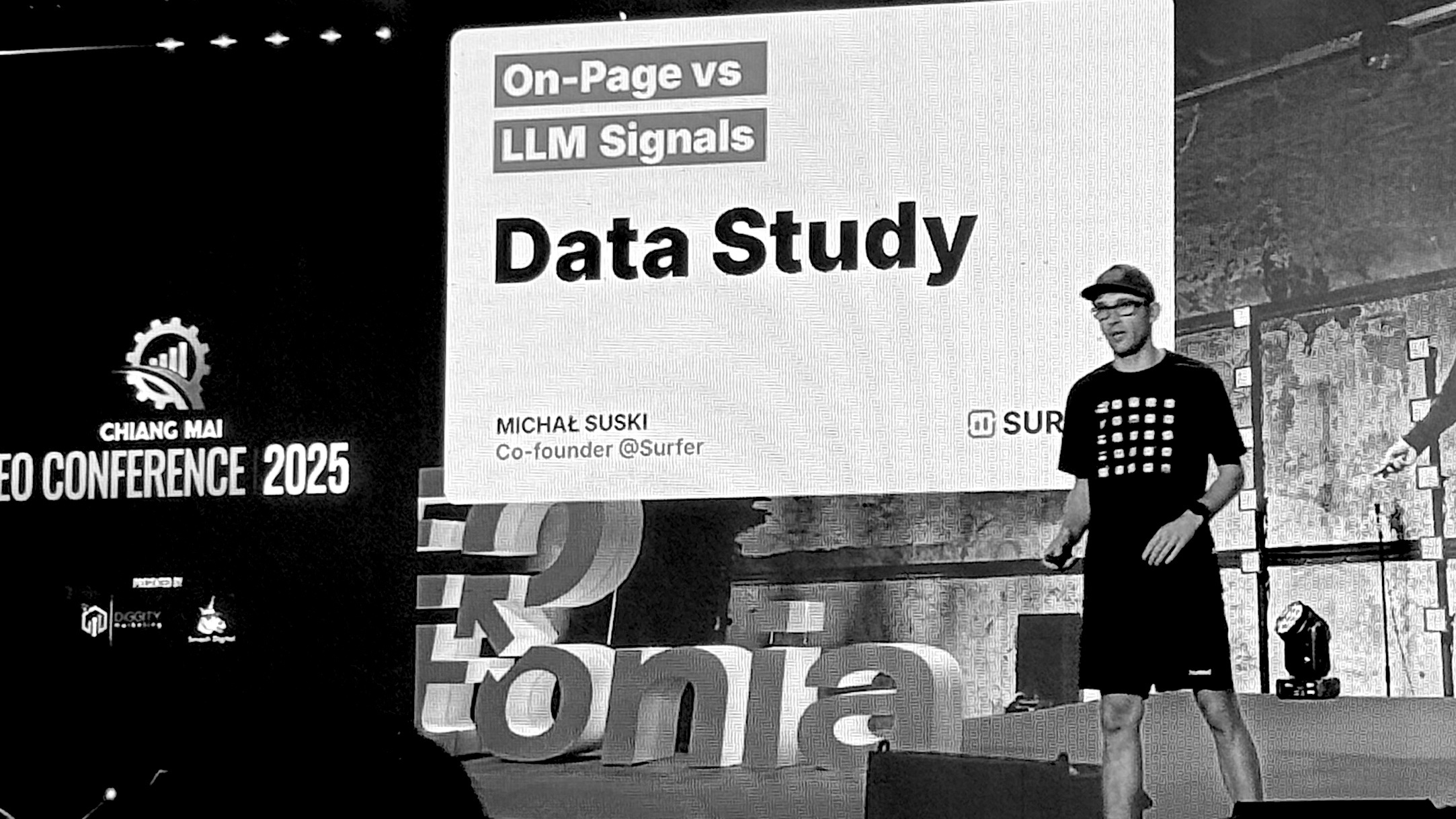 Speaker presents data study on on-page SEO versus LLM signals at the Chiang Mai SEO Conference 2025, emphasizing analytics and search engine trends.