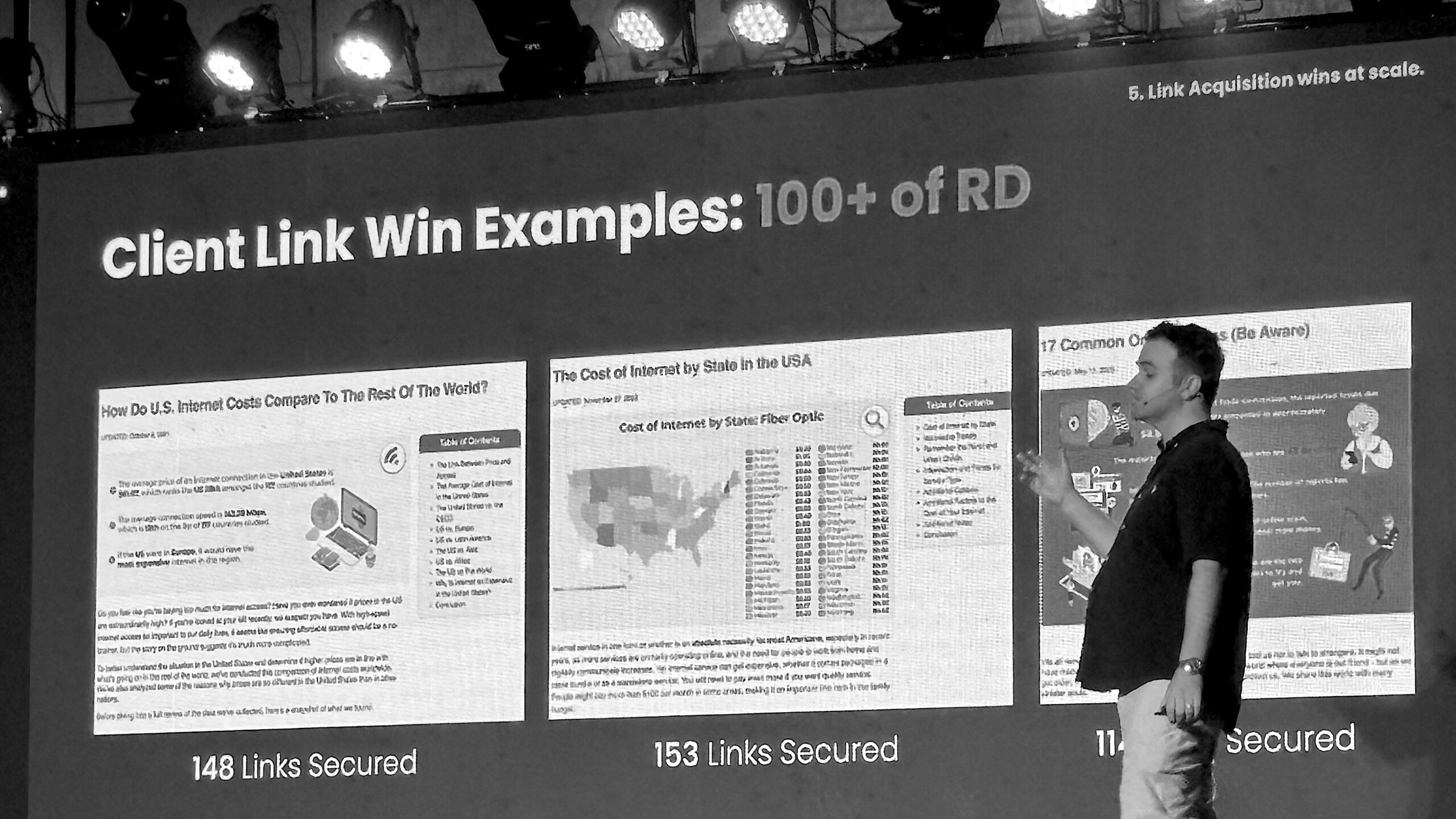 A digital marketing expert presents SEO link building case studies on a large screen, showcasing successful backlink strategies and client wins with visual data charts.